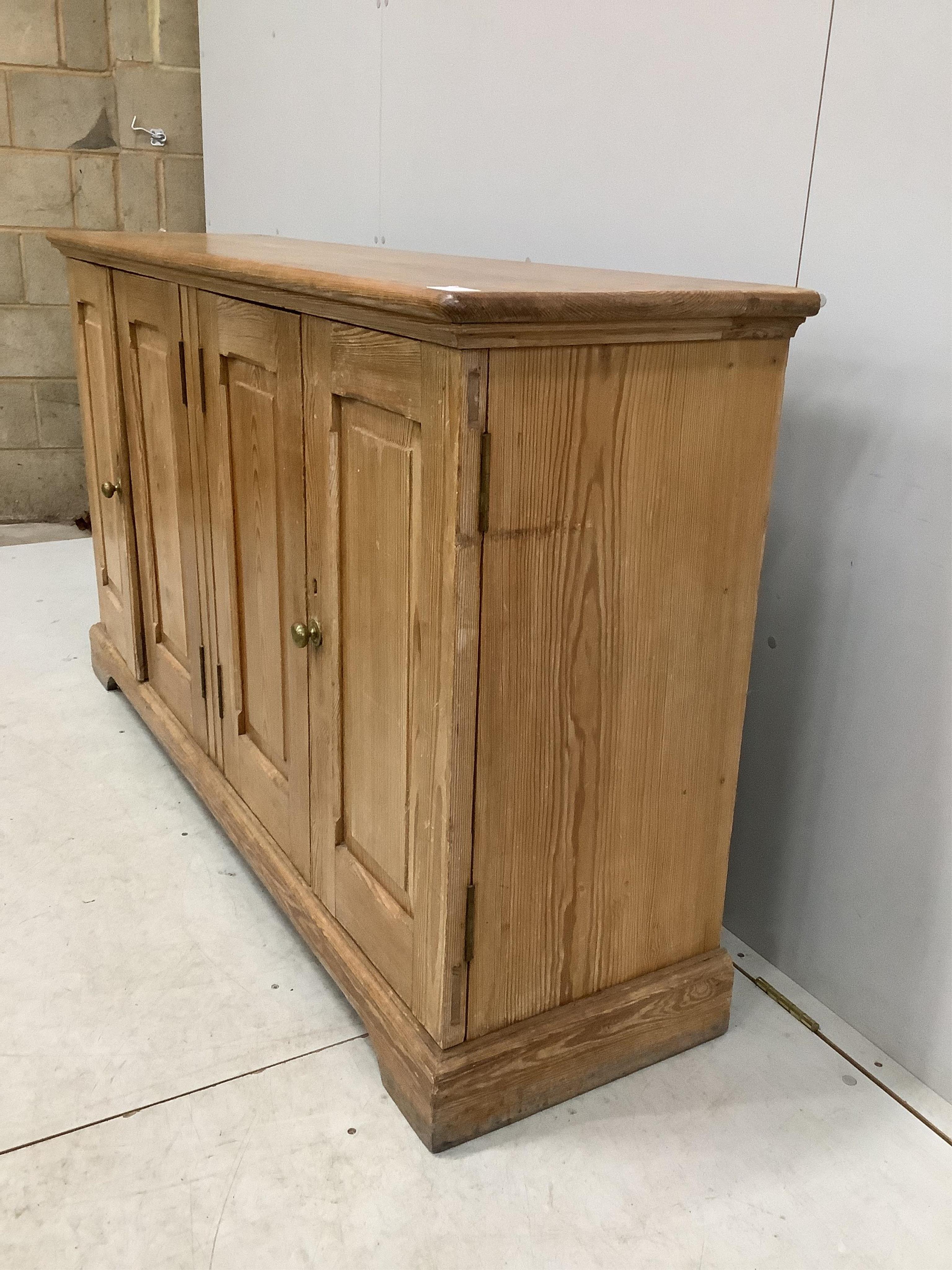 A late Victorian pitch pine four door side cabinet, width 158cm, depth 42cm, height 91cm. Condition - fair